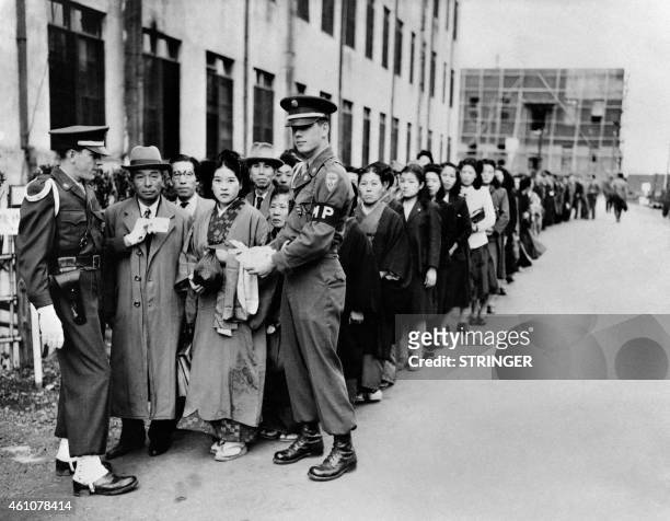 Photo taken around 1946 in Tokyo shows Japanese people queuing outside the The International Military Tribunal for the Far East where the leaders of...