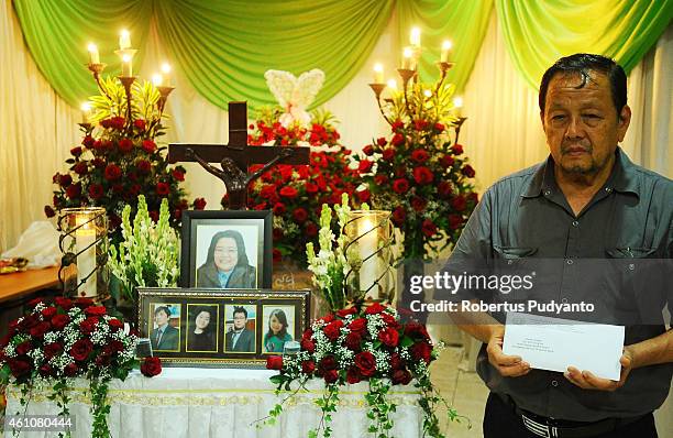 Father of Shiane Josal, a victim of the AirAsia flight QZ8501 disaster stand up near the coffin at Adi Yasa funeral house on January 6, 2015 in...