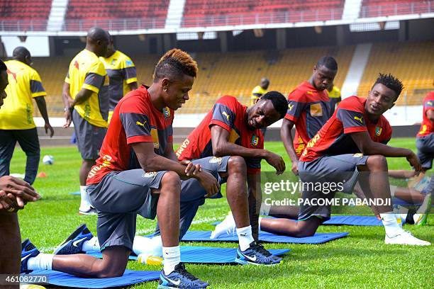 Members of the Cameroon national football team stretch during training in the grounds of the Yaounde Ahmadou Ahidjo Stadium, on January 6, 2015....