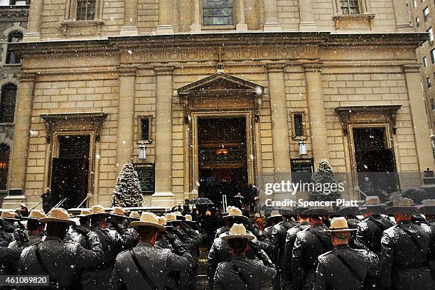 New York State Police wait for the hearse carrying the casket of former three-term governor Mario Cuomo out of St. Ignatius Loyola Church on January...