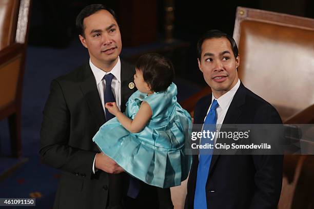 Rep. Joaquin Castro holds his daughter Andrea Elena Castro as he and his twin brother, Housing and Urban Development Secretary Julian Castro, attend...