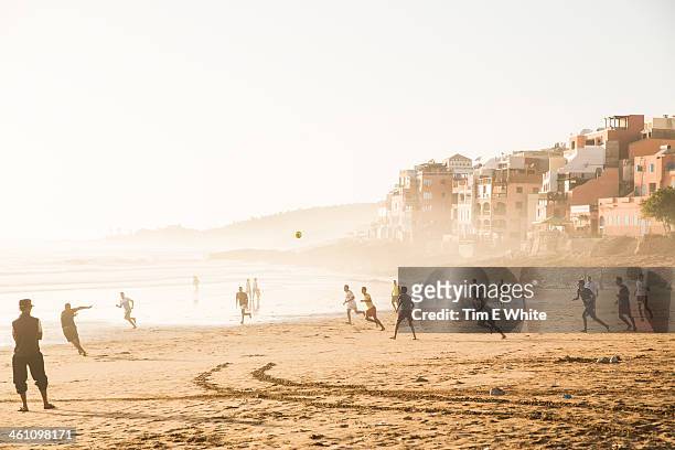 men playing football on the beach, taghazout, moro - agadir - fotografias e filmes do acervo