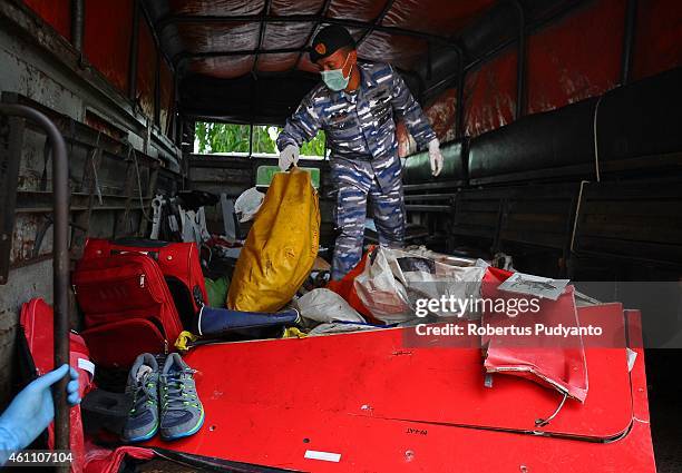 Indonesian Navy personnel show recovered parts of the aircraft AirAsia QZ8501 during a handover ceremony from Indonesian Navy to NTSC to continue...