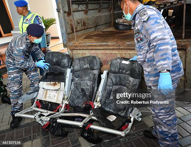 Indonesian Navy personnel show recovered parts of the aircraft AirAsia QZ8501 during a handover ceremony from Indonesian Navy to NTSC to continue...