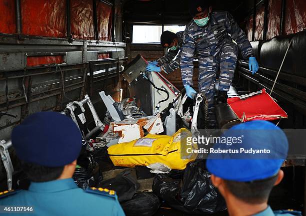 Indonesian Navy personnel show recovered parts of the aircraft AirAsia QZ8501 during a handover ceremony from Indonesian Navy to NTSC to continue...