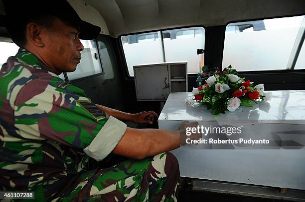 An Indonesian soldier guards a coffin containing a victim of the AirAsia flight QZ8501 disaster on January 7, 2015 in Surabaya, Indonesia. A massive...