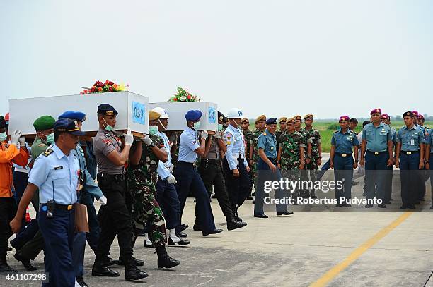 Indonesian Search and Rescue personnel carry coffins containing victims of the AirAsia flight QZ8501 disaster on January 7, 2015 in Surabaya,...