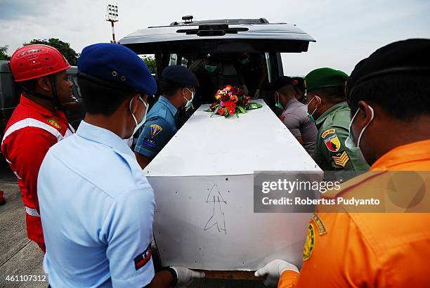 Indonesian Search and Rescue personnel place a coffin containing a victim of the AirAsia flight QZ8501 disaster in an ambulance to continue...