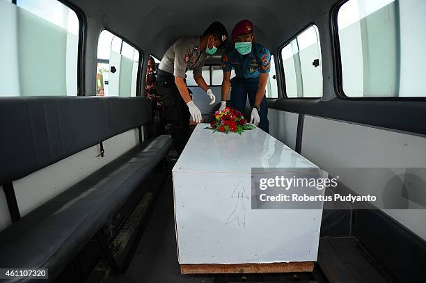 Indonesian Search and Rescue personnel place a coffin containing a victim of the AirAsia flight QZ8501 disaster in an ambulance to continue...