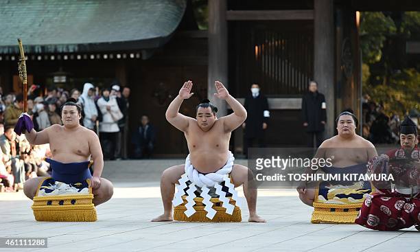 Mongolian-born sumo grand champion, or "yokozuna", Kakuryu performs a ring-entering ceremony beside wrestlers Tachimochi Ikioi , Tsuyuharai Kagamiou...