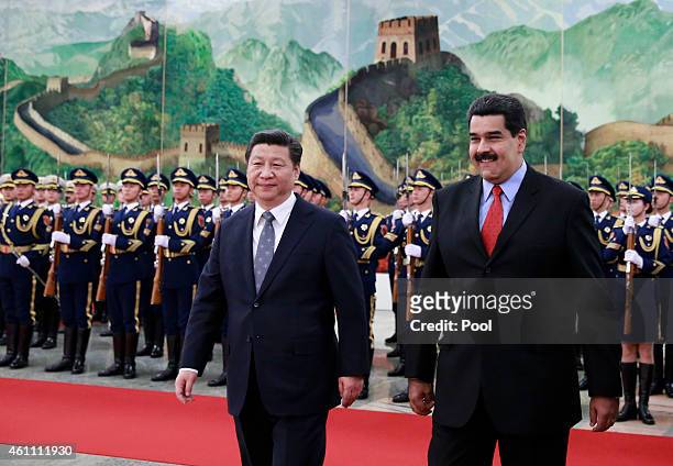 Venezuela's President Nicolas Maduro walks with Chinese President Xi Jinping as they arrive to a welcoming ceremony at the Great Hall of the People...