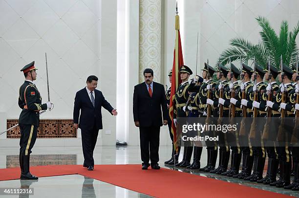 Venezuela's President Nicolas Maduro walks with Chinese President Xi Jinping as they review an honor guard during a welcoming ceremony at the Great...