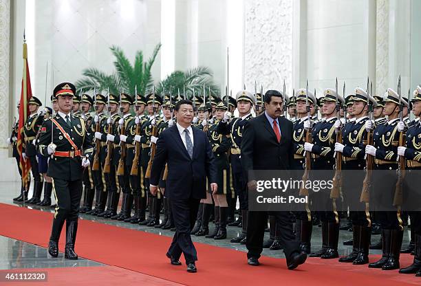 Venezuela's President Nicolas Maduro walks with Chinese President Xi Jinping as they review an honor guard during a welcoming ceremony at the Great...