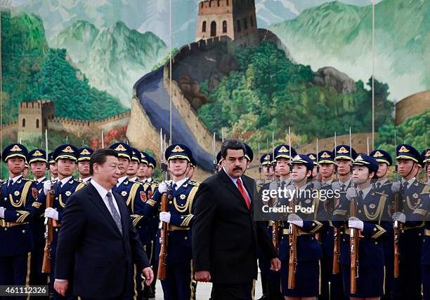 Venezuela's President Nicolas Maduro walks with Chinese President Xi Jinping as they review an honor guard during a welcoming ceremony at the Great...