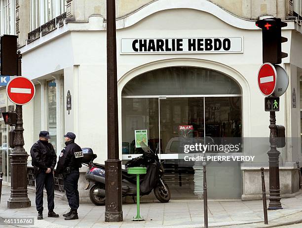 Policeman stand in front of the satirical French weekly "Charlie Hebdo"'s headquarters, 08 February 2006 in Paris. Charlie Hebdo printed all 12 of...