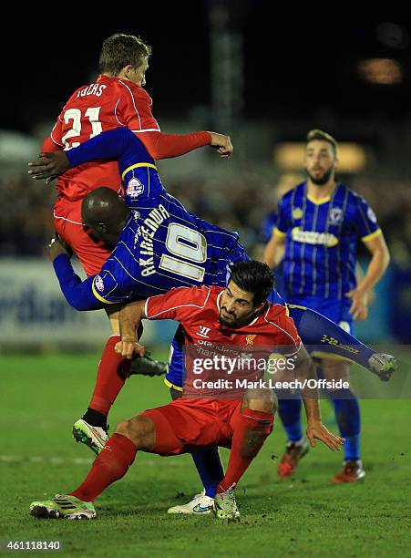 Adebayo Akinfenwa of AFC Wimbledon collides with Lucas Leiva and Emre Can of Liverpool during the FA Cup Third Round match between AFC Wimbledon and...