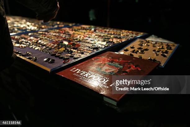 The Official history of Liverpool FC is seen for sale alongside numerous pin badges outside the stadium during the FA Cup Third Round match between...