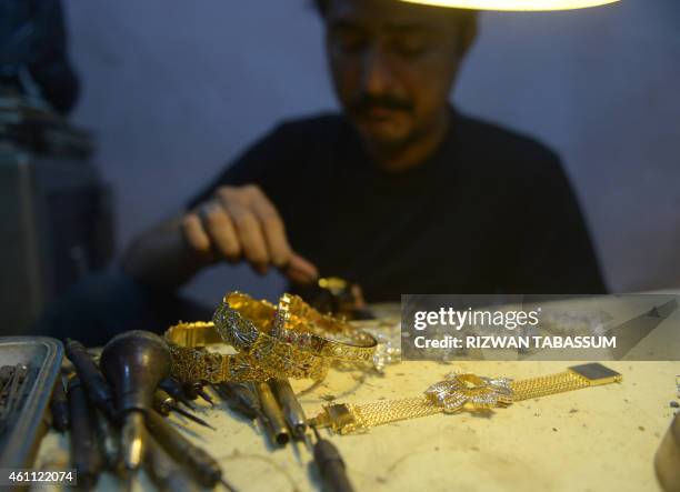 Pakistani jeweller makes a necklace at his gold workshop in Karachi on January 7, 2015. The International Monetary Fund announced December 2014 that...