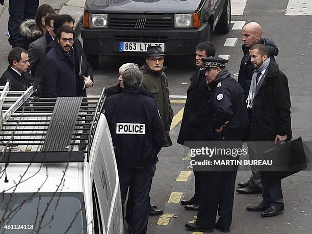 French Prime Minister Manuel Valls listens to former director of the satirical political Charlie Hebdo Philippe Val outside of the offices of the...