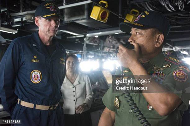 Cmdr. Steven Foley, commanding officer of the guided-missile destroyer USS Sampson , listens as Gen. Moeldoko, commander of the Indonesian National...