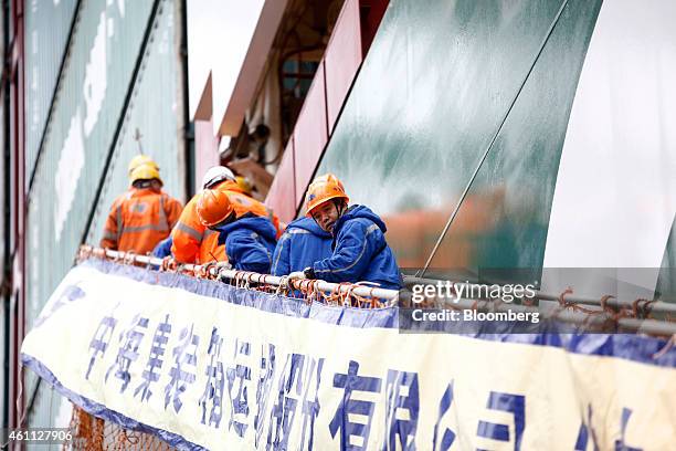 Crew members climb a staircase aboard the world's largest container ship, the CSCL Globe, operated by China Shipping Container Lines Co., as it sits...