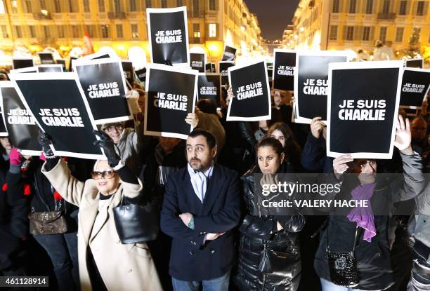 People hold up placards reading in French, "I am Charlie" during a gathering in Nice, southeastern France, on January 7 following an attack by...