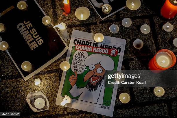 Cartoon lies on the ground while people gather at a vigil in front of the French Embassy following the terrorist attack in Paris on January 7, 2015...