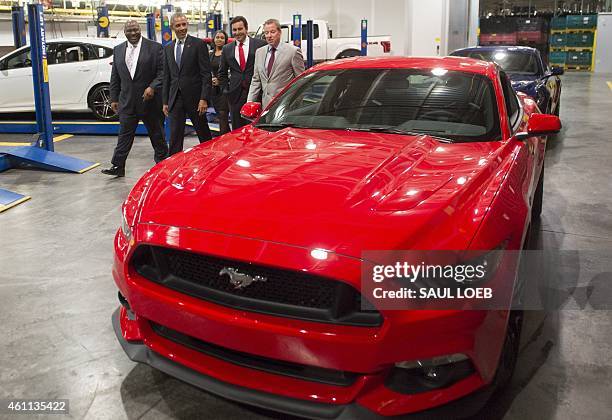 President Barack Obama takes a look at a Ford Mustang prior to speaking about the automotive manufacturing industry at the Ford Michigan Assembly...