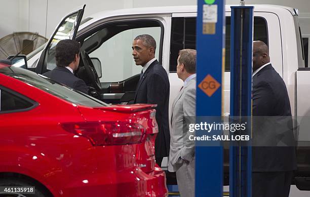 President Barack Obama looks at Ford vehicle before speaking about the automotive manufacturing industry at the Ford Michigan Assembly Plant in...