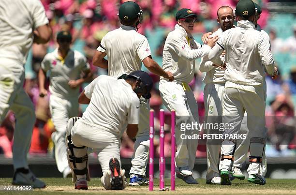 Australia's spinner Nathan Lyons is congratulated by teammates after bowling out India's batsman Karn Sharma during day three of the fourth cricket...