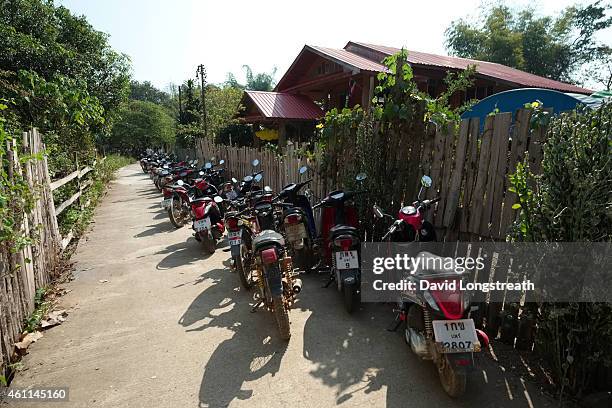 Motorcycles park outside on a narrow lane during ceremonies at the wedding of Kanokporn and Montri Thi in Ta Par Mok, Thailand. Thai Buddhist...