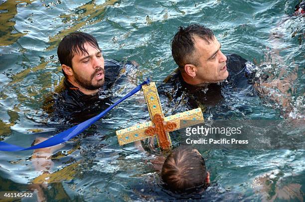 Swimmers hold the Holy Cross on their hands. Greek Orthodox in Piraeus celebrated the Blessing of The Waters or 'Theophany' day in the port of...