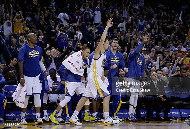 Klay Thompson of the Golden State Warriors reacts with the bench players including Stephen Curry after he made a three-point basket against the...