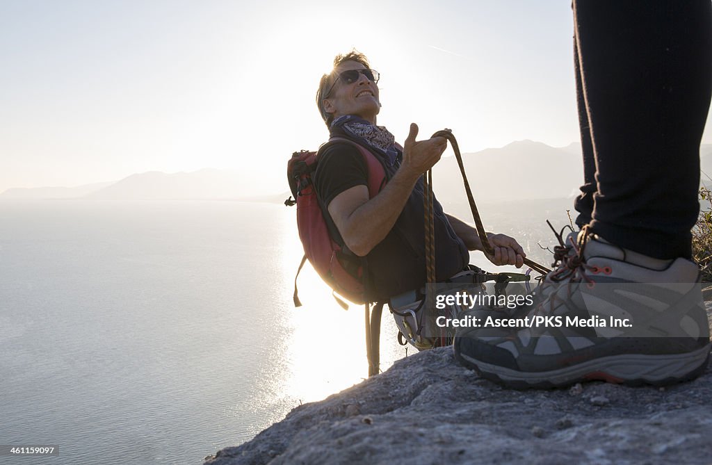 Rock climber demonstrates rope handling to partner