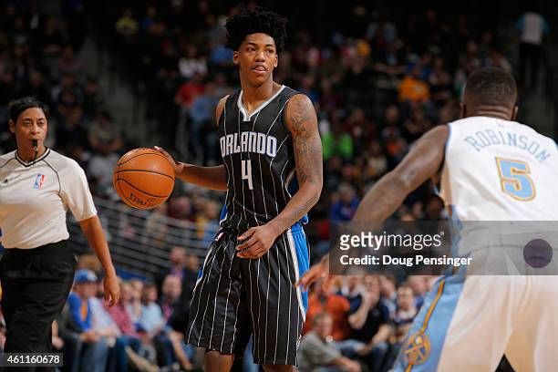 Elfrid Payton of the Orlando Magic controls the ball against Nate Robinson of the Denver Nuggets as referee Violet Palmer oversees the action at...