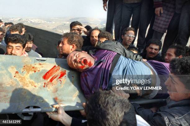 Palestinians evacuate a dead fellow shot in the head during clashes with Israeli troops on February 25 after the Cave of the Patriarchs massacre...