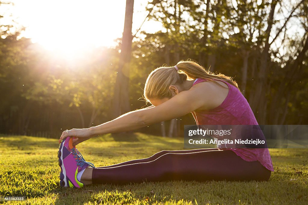 Woman stretching at sunset