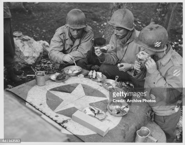 Soldiers of the 3rd Division having Christmas dinner on the hood of a jeep on the front lines, World War Two, France, December 25th 1943.