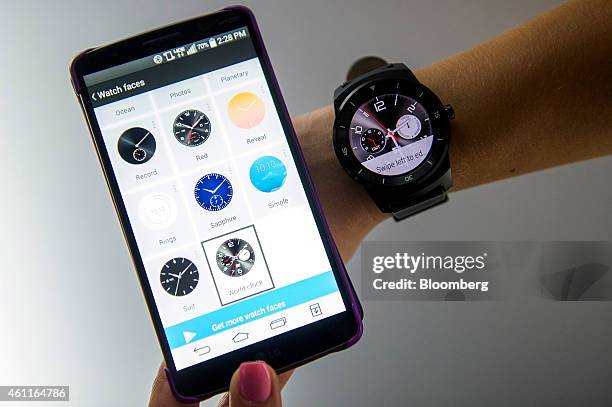 An exhibitor demonstrates an LG G Watch R smartwatch, manufactured by LG Electronics Inc., right, alongside an LG smartphone during the 2015 Consumer...