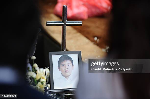 Relatives of Grayson Herbert Linaksita, victims of the AirAsia flight QZ8501 disaster, pray during the funeral ceremony at Sentong Cemetery on...