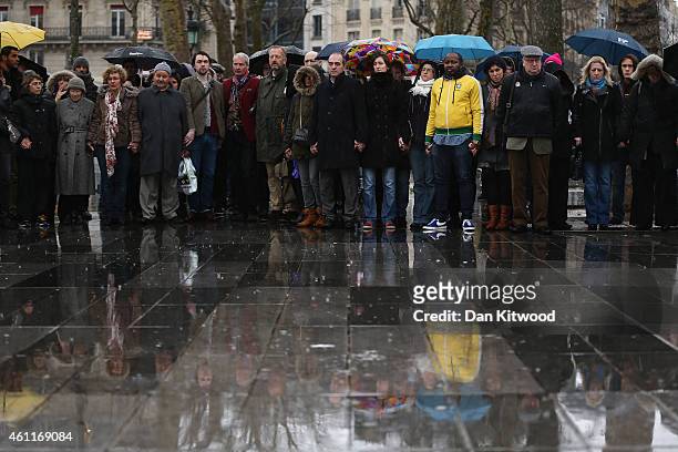 People hold hands and form a circle around the Place de la Republique at midday in solidarity with victims of yesterday's terrorist attack on January...