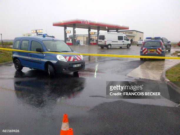 French Gendarmerie cars are parked behind a police cordon at an Avia gas station in Villers-Cotterets, north-east of Paris, on January 8 where the...