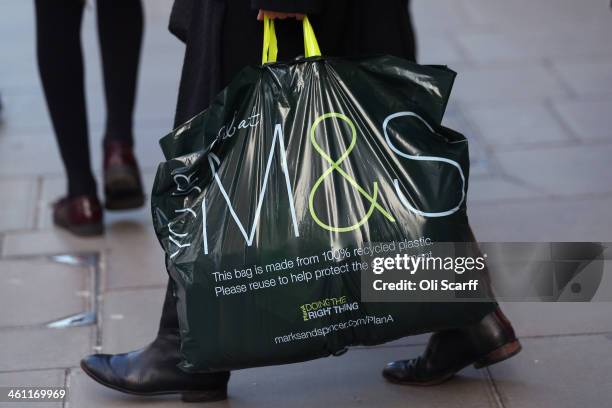 Shopper carries an M&S bag out of a branch of Marks & Spencer on January 7, 2014 in London, England. The food and clothing retailer, which has traded...