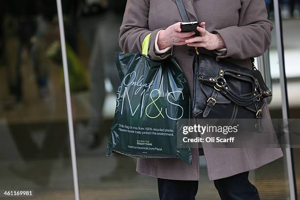Shopper carries an M&S bag out of a branch of Marks & Spencer on January 7, 2014 in London, England. The food and clothing retailer, which has traded...