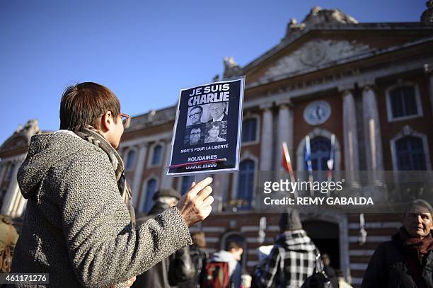 Woman holds a sign reading ''I am Charlie, dead for freedom'' and bearing pictures of French satirical weekly Charlie Hebdo's cartoonists Charb,...