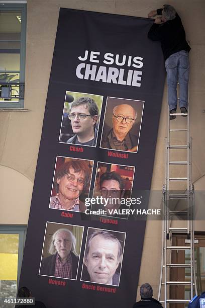 Peope put up a banner reading "Je suis Charlie" featuring the portraits of late Charlie Hebdo editor Stephane Charbonnier , late French cartoonists...