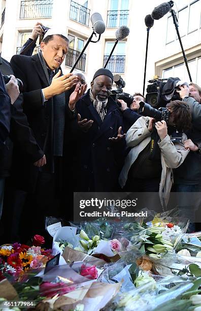 Hassen Chalghoumi , Imam of the Drancy mosque in Paris, leaves flowers and prays near the 'Charlie Hebdo' offices on a day of mourning following a...