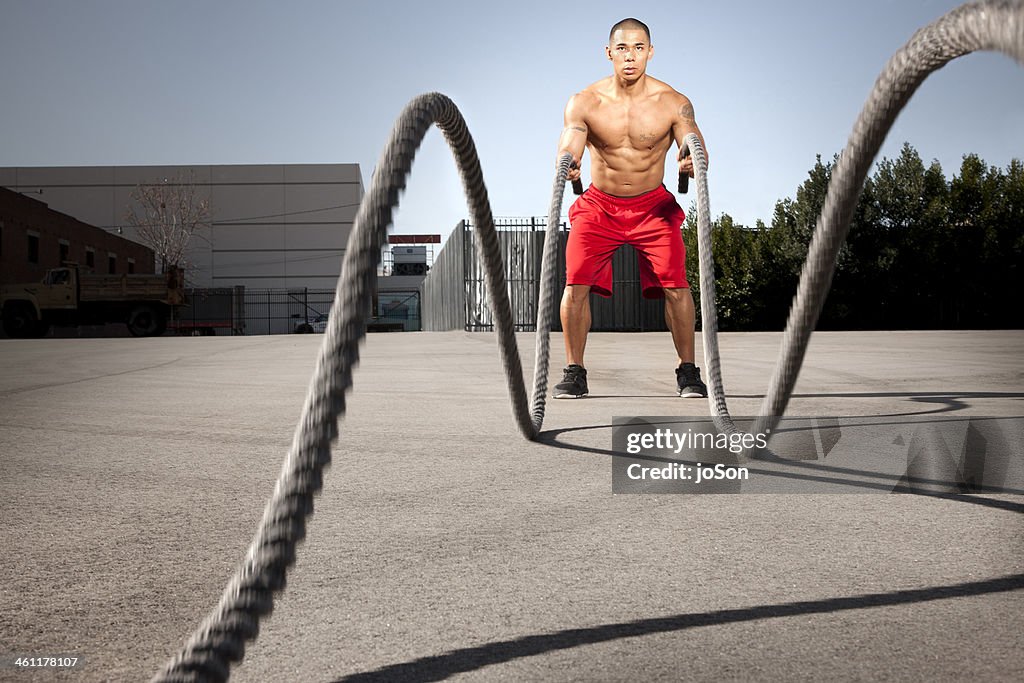 Man using heavy rope exercises training