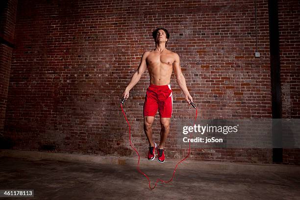 man in mid air with skip rope - seilspringen stock-fotos und bilder