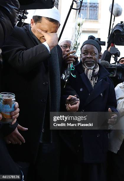 Hassen Chalghoumi , Imam of the Drancy mosque in Paris, leaves flowers and prays near the 'Charlie Hebdo' offices on a day of mourning following a...